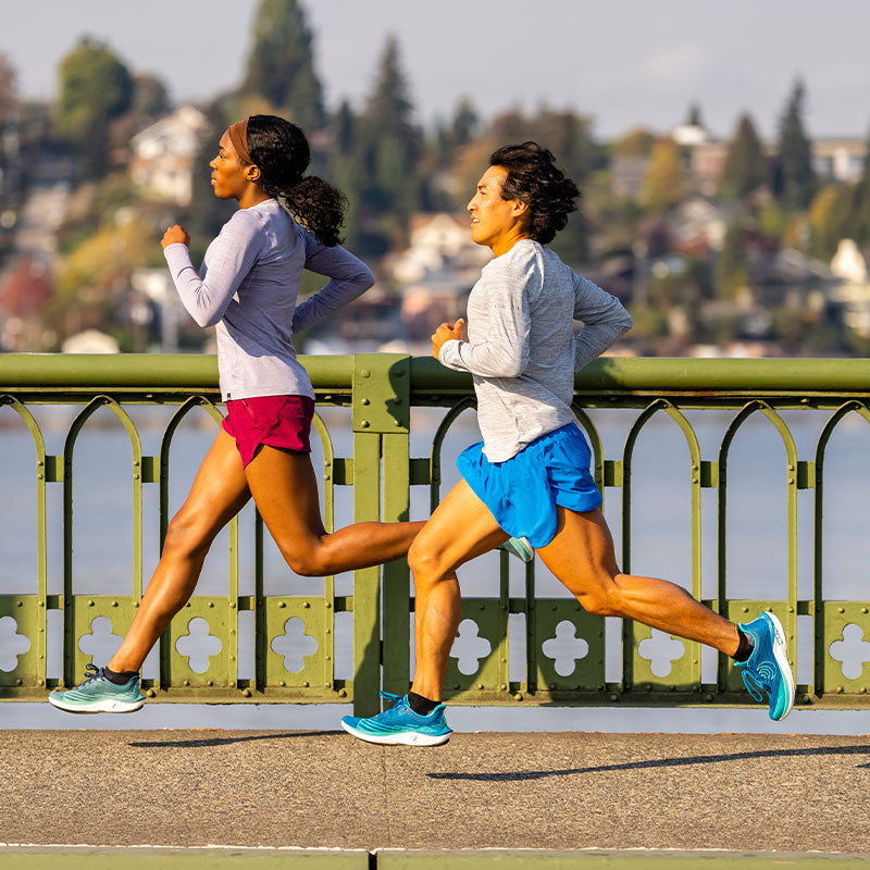 Decorative image of a man and woman running on a sidewalk in Topo Athletics road running shoe named the Cyclone 2